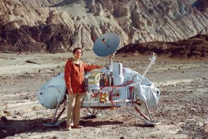 Carl Sagan poses with a model of the Viking lander in Death Valley